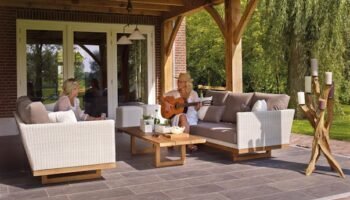 Home Two women enjoying a serene patio scene with a guitar and candles, surrounded by greenery.